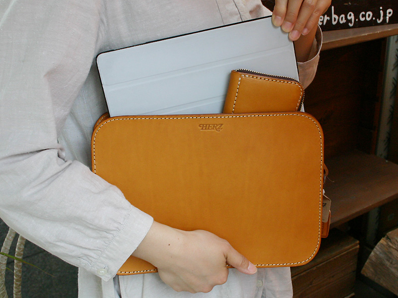 革好きの男性が持つシンプルな薄マチタイプのセカンドバッグ / 革鞄の