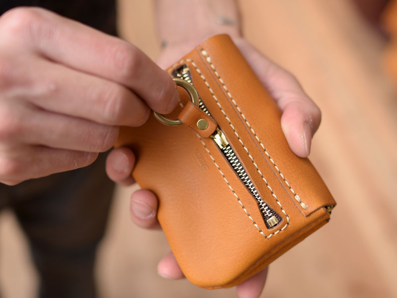 丸いフォルムと遊び心溢れるデザインが愛らしい二つ折り財布「革鞄の 