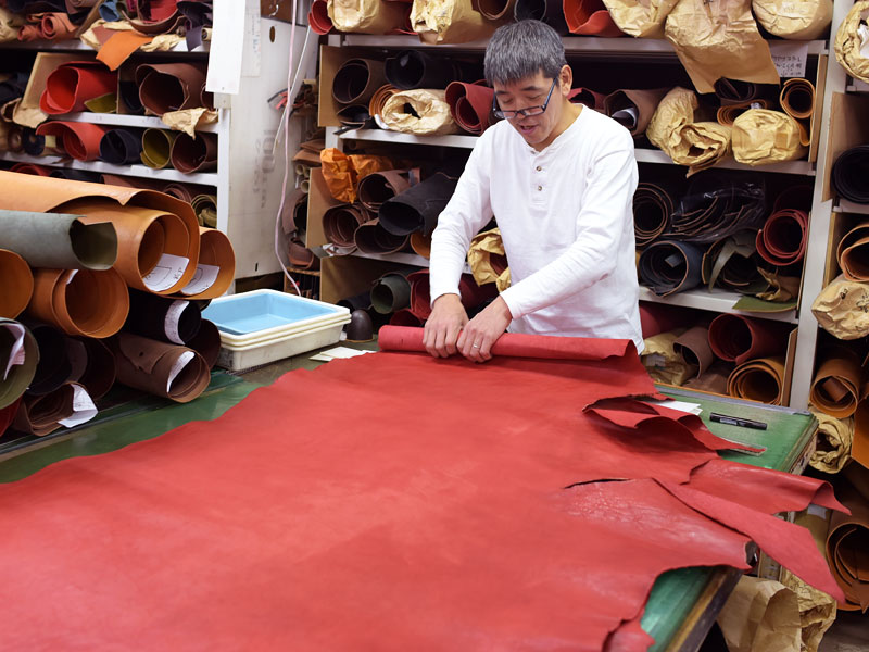 赤い革を巻く渋谷工房の作り手